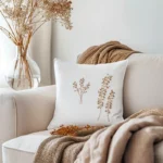 a wildflower embroidered pillow on the sofa with a soft blanket, creating a comfortable atmosphere