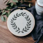 dark green floral wreath hand embroidery resting on the table