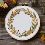 floral wreath hand embroidery with yellow and green leaves and red flower centers