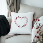 gray sofa adorned with a white cushion and a black blanket