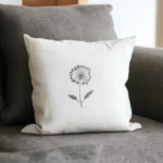 gray sofa with a white cushion featuring a dandelion embroidery design
