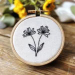 hand embroidery piece featuring two delicate wildflowers