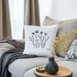 sofa with a handmade embroidered cushion and a cozy throw blanket