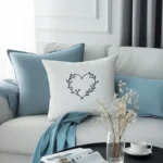 blue and white cushions arranged on a sofa with a coffee table beside it