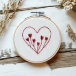 hand embroidery artwork featuring a heart-shaped outline with a growing heart design inside