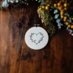leaf-decorated heart embroidery centered with natural leaves and small berries