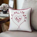 red heart hand-embroidered cushion placed on a chair