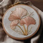 close-up of pink fan-shaped mushroom hand embroidery in a wooden hoop