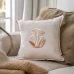 decorative throw pillow with a stitched woodland mushroom and leaf design