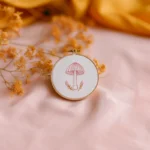 minimalist stitched mushroom design in a hoop styled with yellow dried flowers