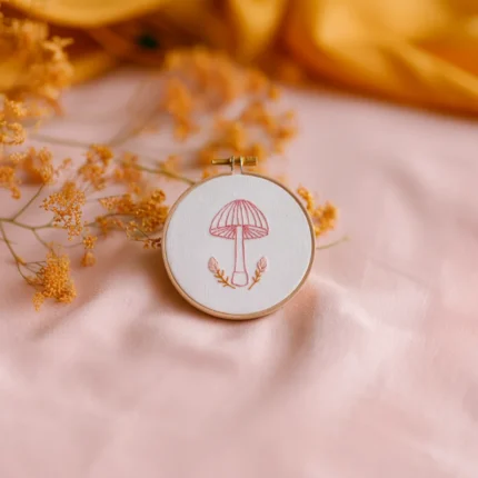 minimalist stitched mushroom design in a hoop styled with yellow dried flowers