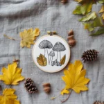 mushroom line art and gold leaves embroidery in a hoop