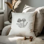 white decorative cushion featuring a stitched minimalist mushroom pattern resting on a cozy beige sofa
