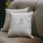 white throw pillows with a single embroidered mushroom design on a sofa